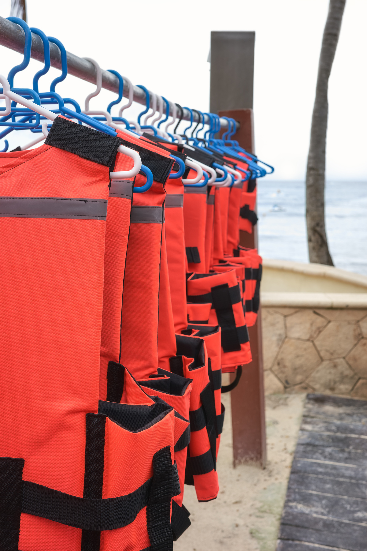 Life jackets dry on hangers at a beach, selective focus.